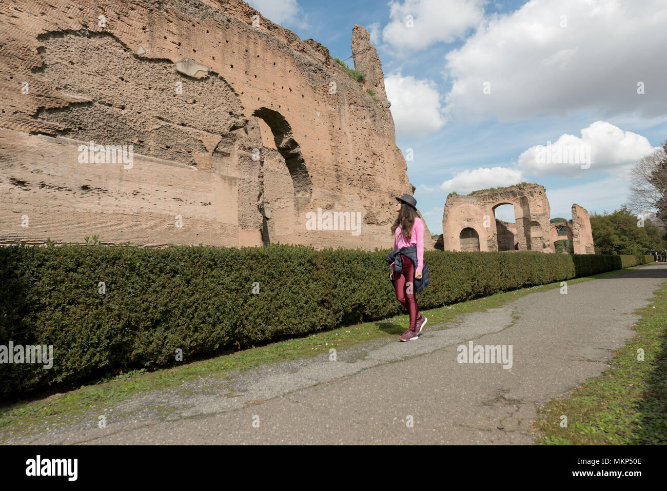 Horizontal picture of black hair woman walking at Baths of Caracalla