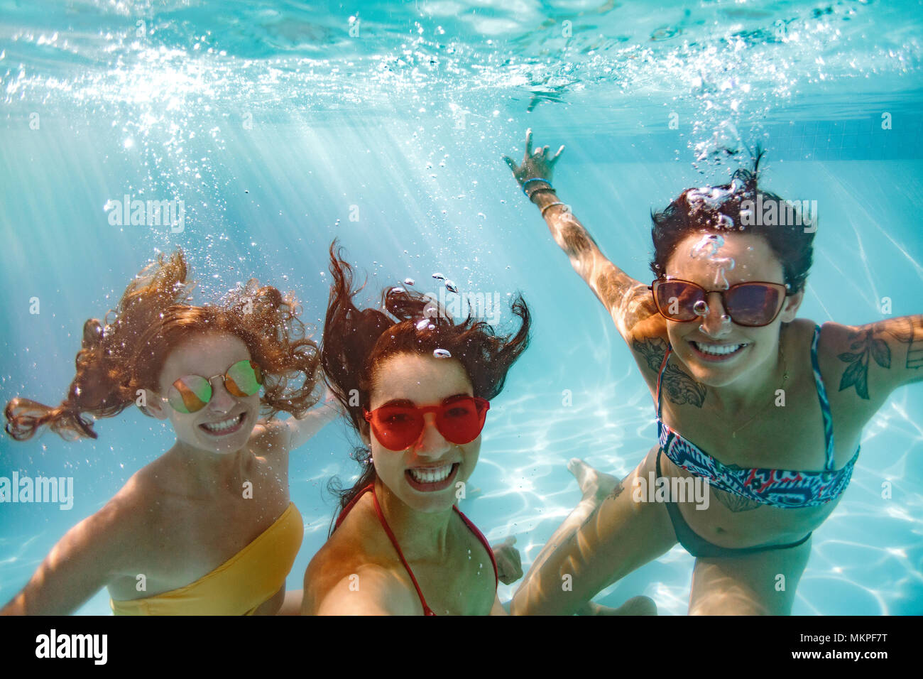 Happy Young Women Friends Swimming Underwater In Pool Underwater Shot Of Smiling Females In