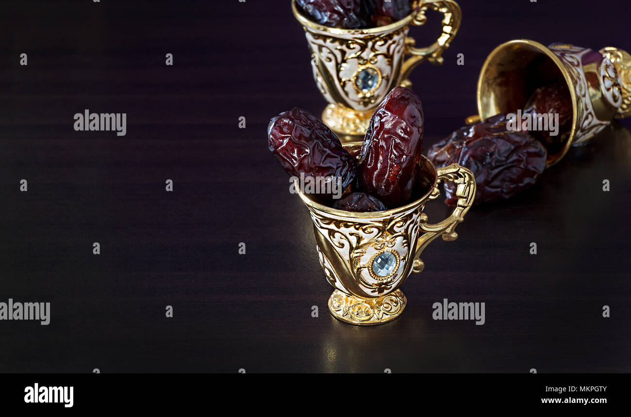 Still life with dates and goldenTraditional Arabic coffee set with mini cup. Dark background. Copy space. Stock Photo