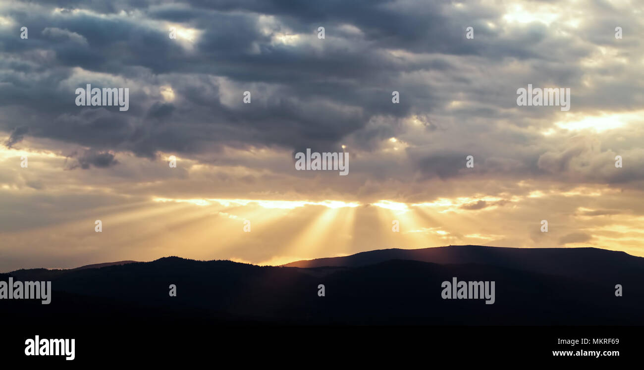Beautiful sunset landscape with sunrays on a cloudy sky Stock Photo