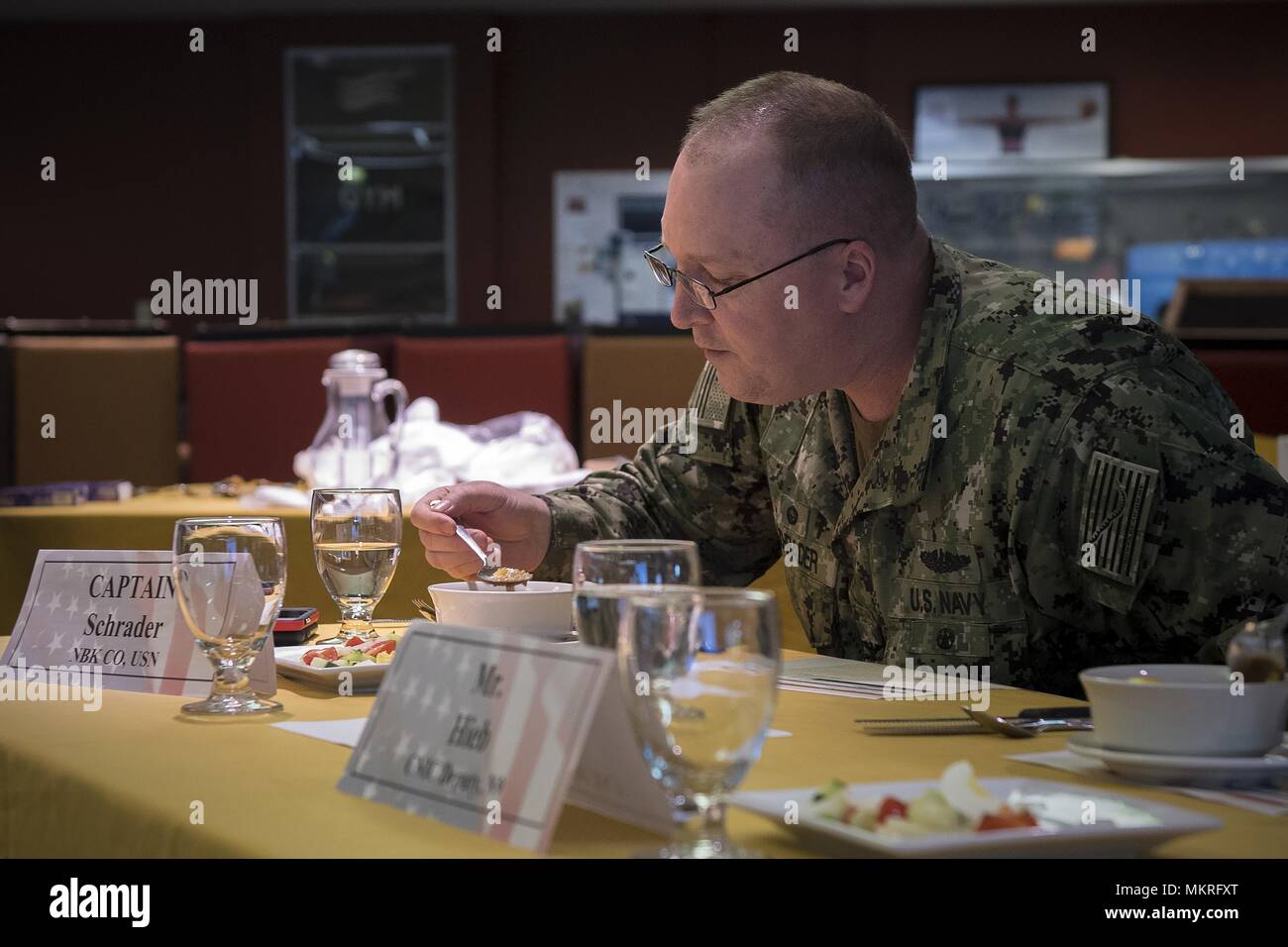 180505-N-EH218-0022 BREMERTON, Wash. (May 5, 2018) Capt. Alan Schrader, commanding officer, Naval Base Kitsap, samples an entry during the 26th Annual Armed Forces Culinary Arts Competition, May 5, 2018. Each year, service members from Naval Base Kitsap, Joint Base Lewis-McChord, Naval Station Everett, Naval Air Station Whidbey Island and other commands throughout the Pacific Northwest come together to compete in a battle of culinary ability for the title of 'Iron Chef. ' (U.S. Navy photo by Mass Communication Specialist 2nd Class Ryan J. Batchelder/Released). () Stock Photo