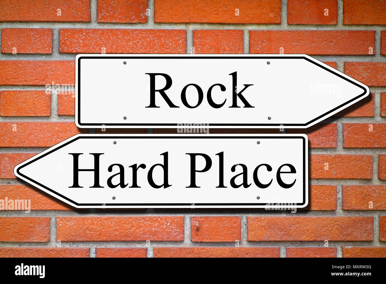 Between rock and hard place signpost concept bricks wall Stock Photo