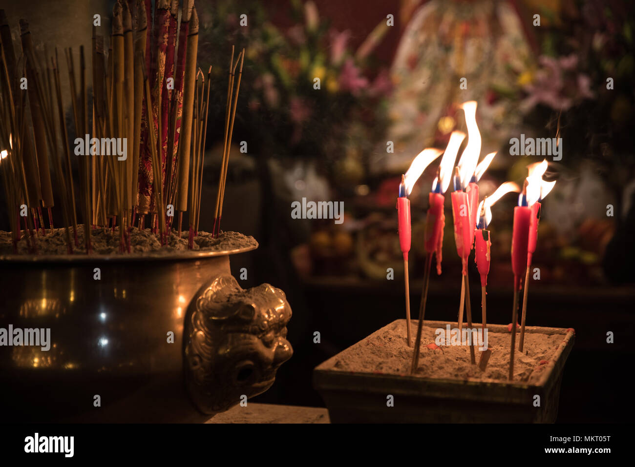 Candlelight from burning candles and incense sticks for praying in