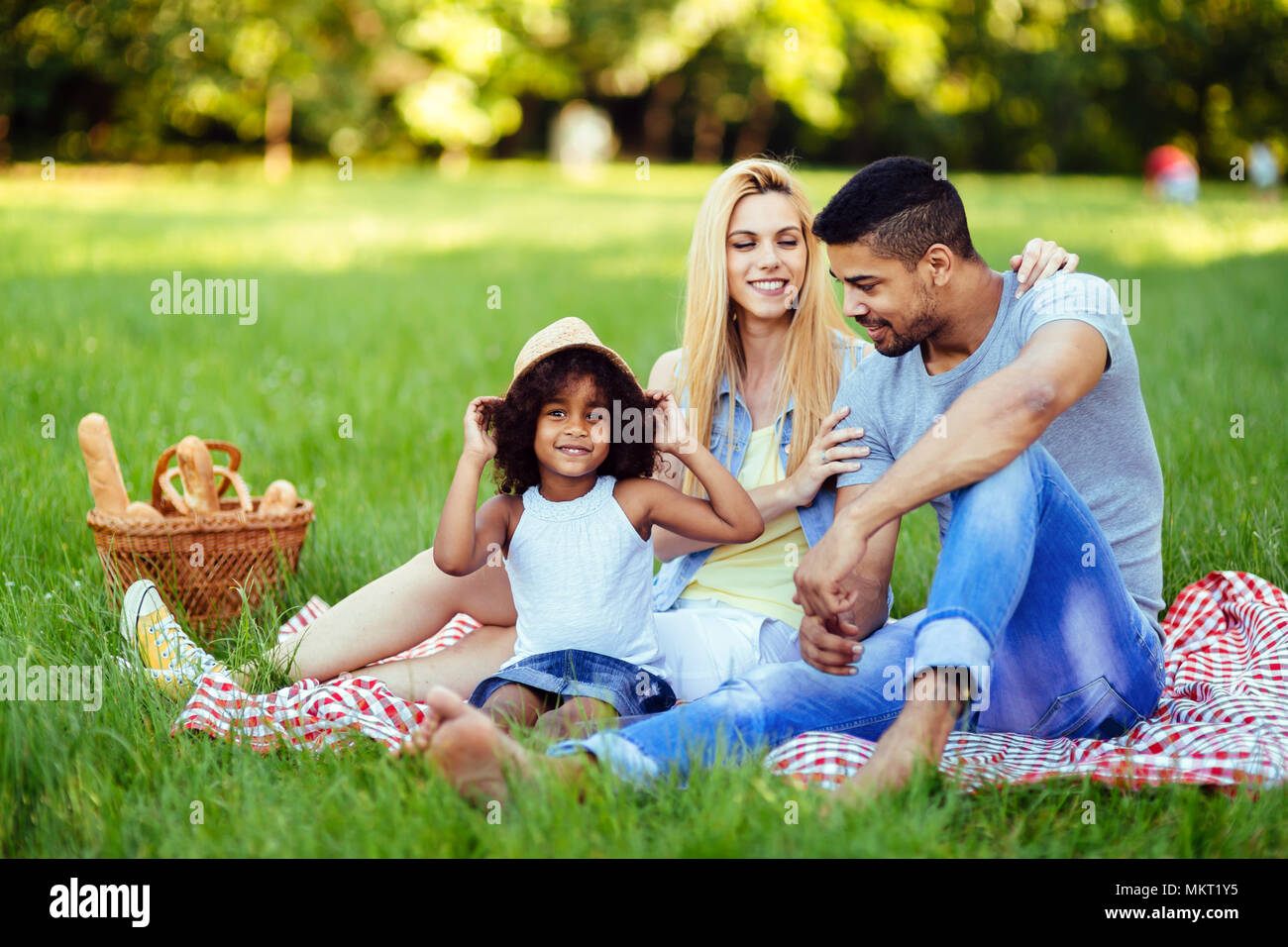 Picture of lovely couple with their daughter having picnic Stock Photo