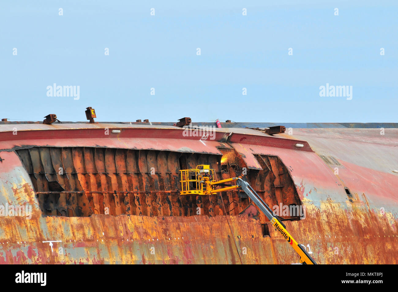 Oxy-fuel cutting torch flames at the top of a Haulotte platform, with plates removed from the hull of the Riverdance Ferry wreck, Anchorsholme, UK Stock Photo