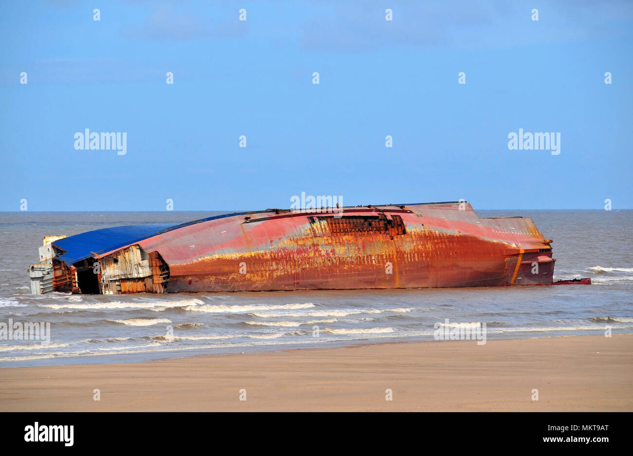 Blue sky high tide sand beach view of Riverdance ship wreck lying on side, with bows and stern removed, Anchorsholme, Cleveleys, Lancashire, UK Stock Photo