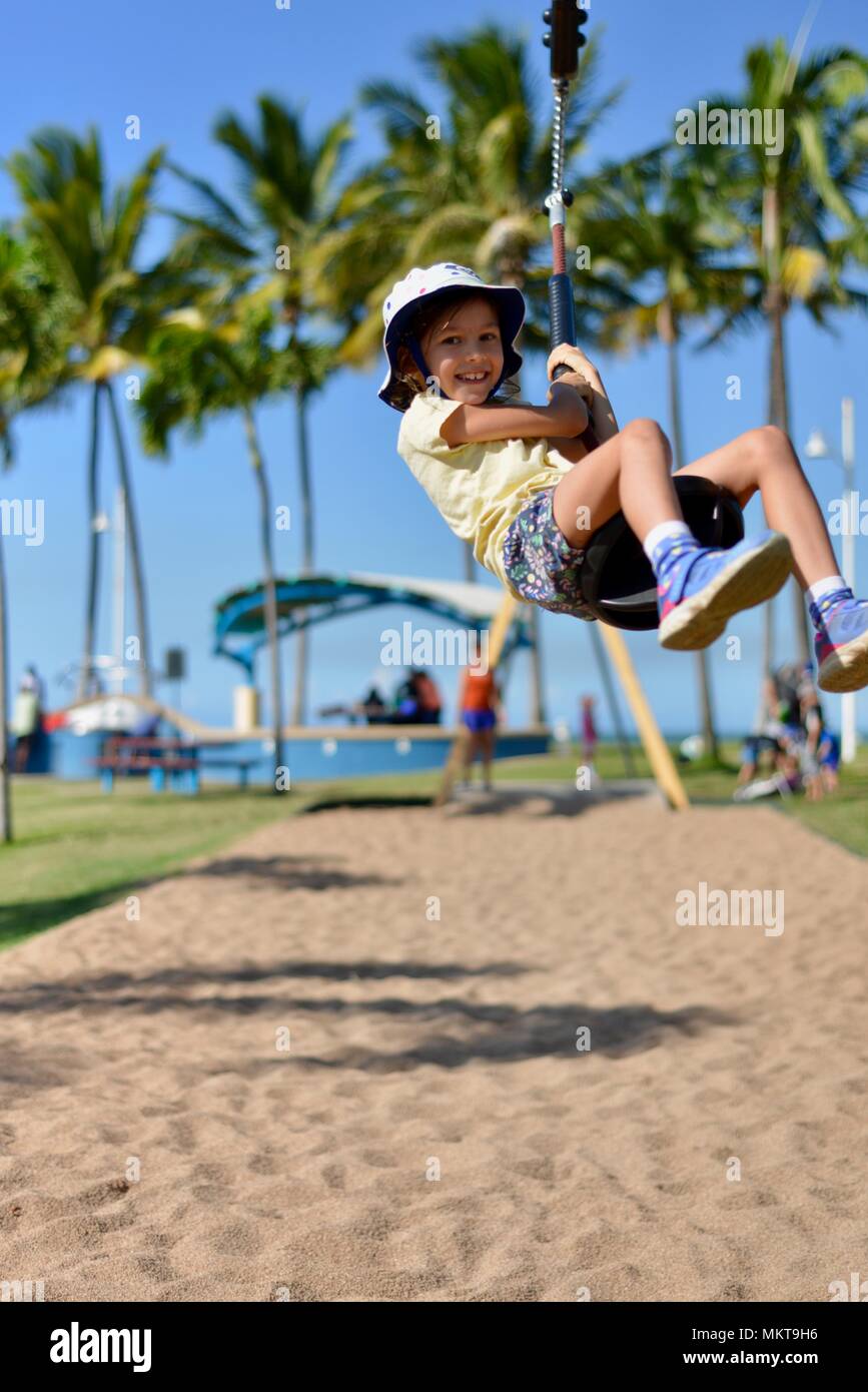 Child riding on a flying fox, near the rockpool and Jezzine barracks, Kissing point fort, Townsville Queensland, Australia Stock Photo