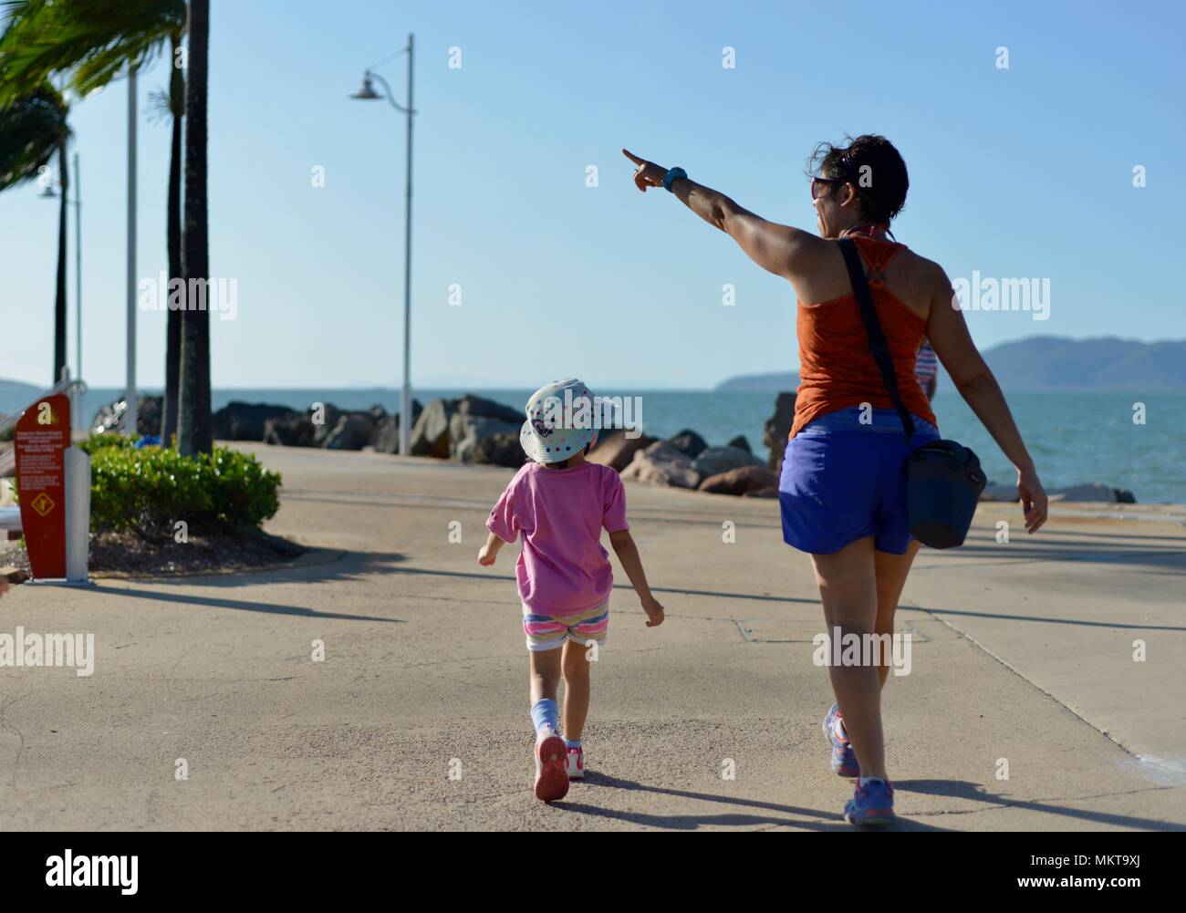 Mother and children walking together in the late afternoon around the rockpool, Jezzine barracks, Kissing point fort, Townsville Queensland, Australia Stock Photo