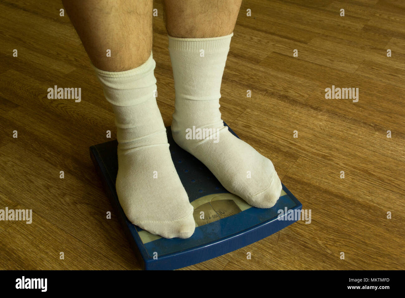 Legs in white socks stand on mechanical scales of blue color (front view  Stock Photo - Alamy