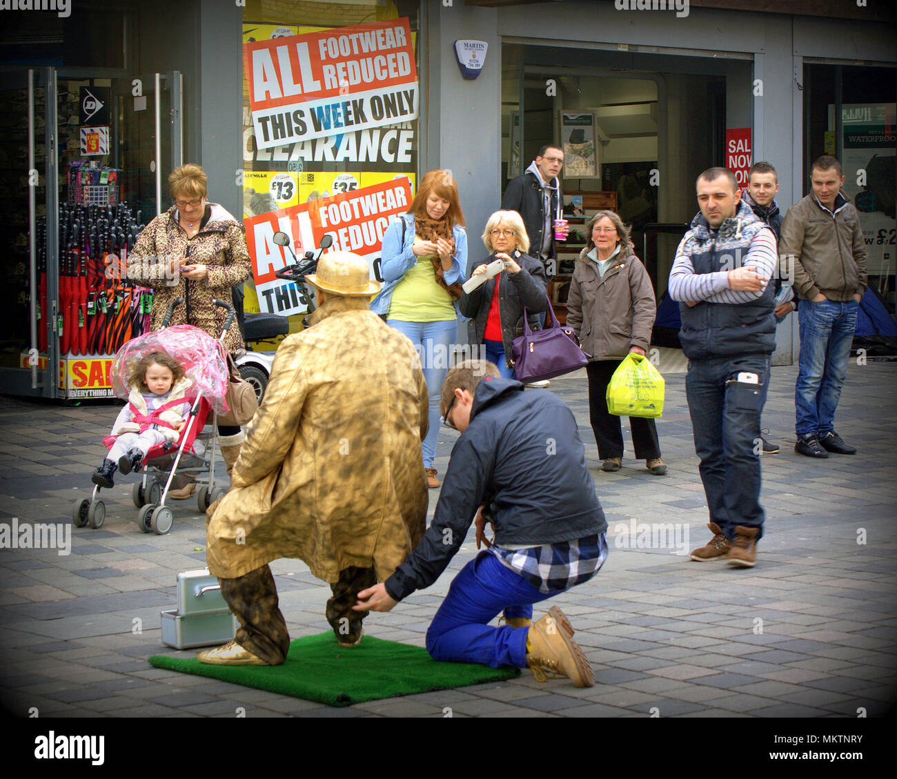 audience crowd magical invisible chair street entertainer being tested foe wires Sauchiehall Street, Glasgow Stock Photo