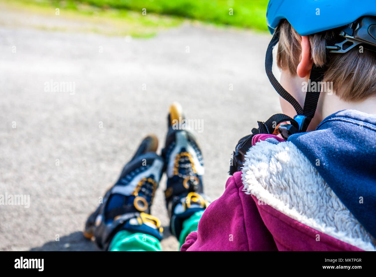 Boy wearing rollerblades sitting and eating and drinking mineral water