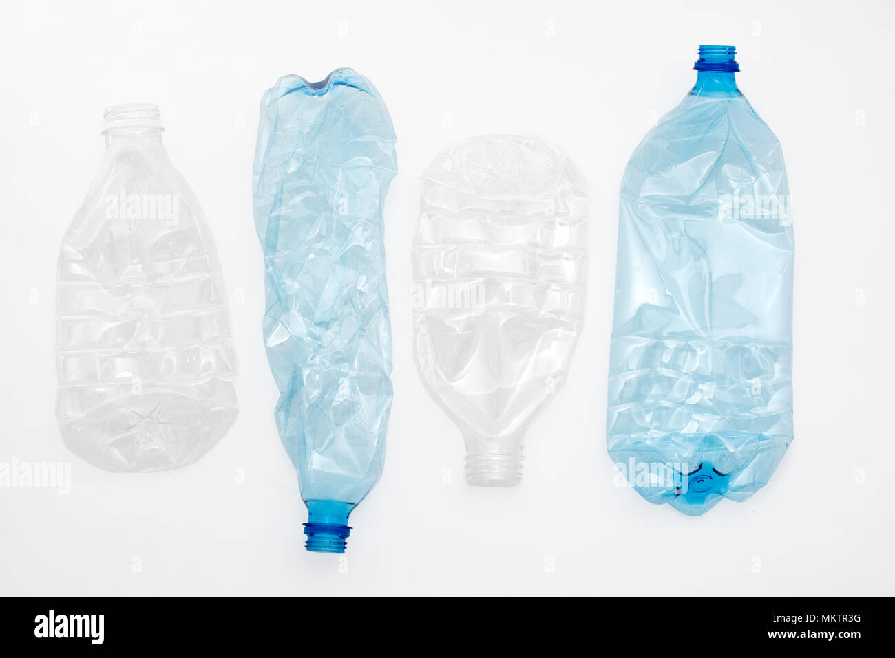 Empty crushed plastic bottles on light background. Stock Photo