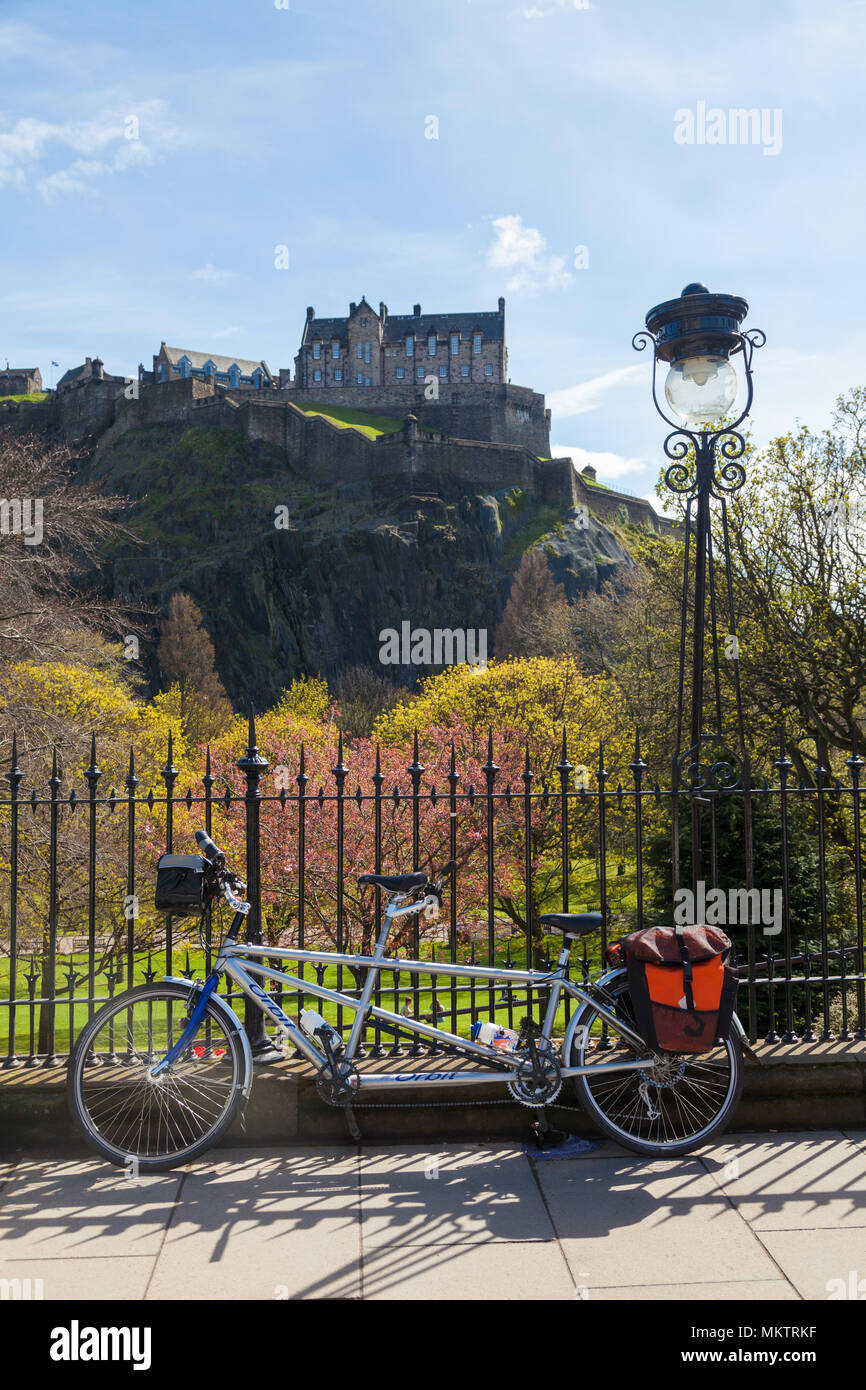 A tandem bicycle resting against railings of Princess Street with Edinburgh Castle in the