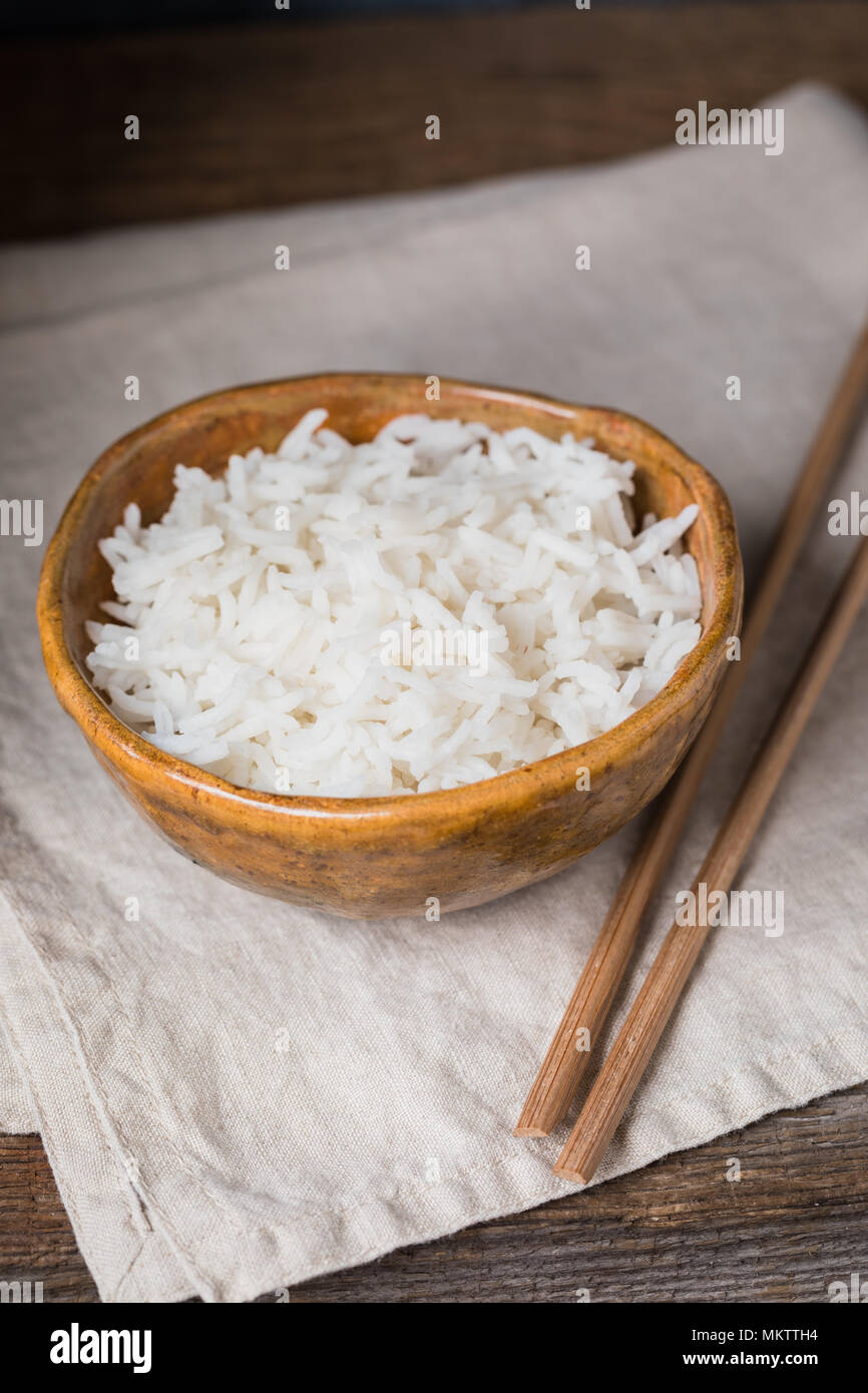 Bowl with white rice on the wooden background, wabi sabi style, toned