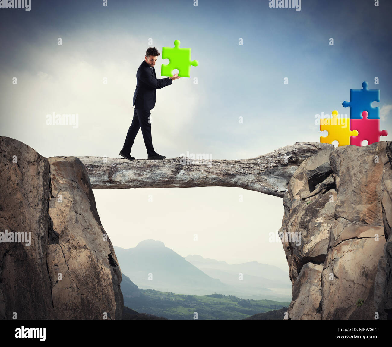 Businessman carries a piece of puzzle while he walking on a tree trunk. concept of missing piece Stock Photo