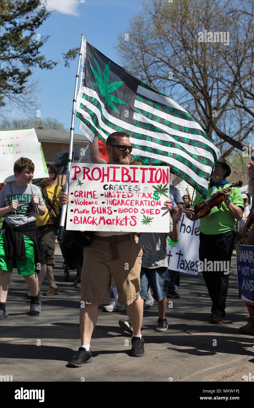 A man holding a sign supporting legalization of marijuana at the May Day parade and festival in Minneapolis, Minnesota, USA. Stock Photo