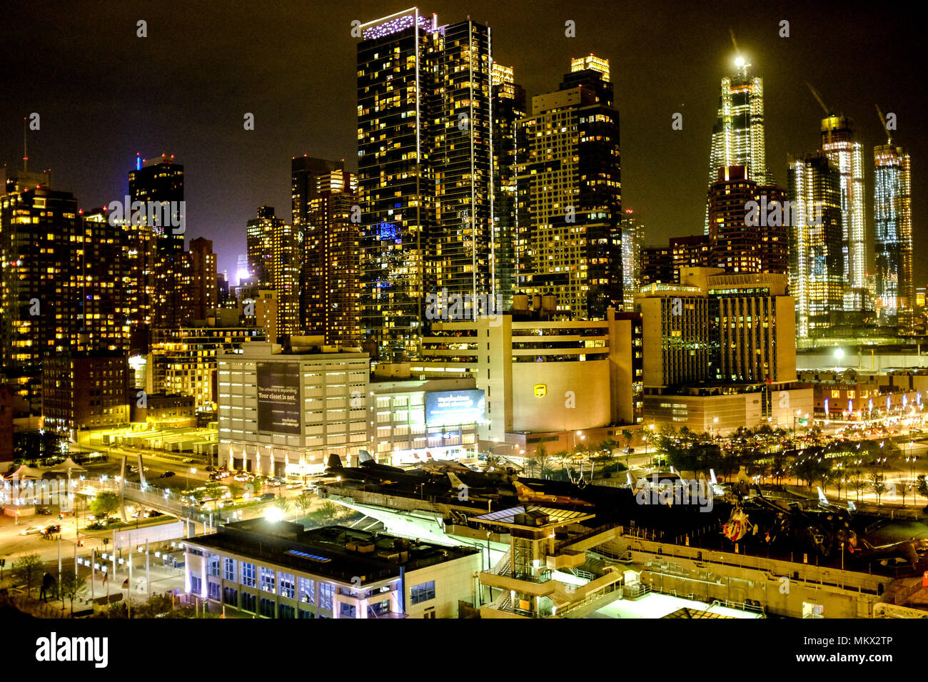 Nighttime skyline views of New York City, shot from the Norwegian Bliss deck, including USS Intrepid in the foreground. Stock Photo