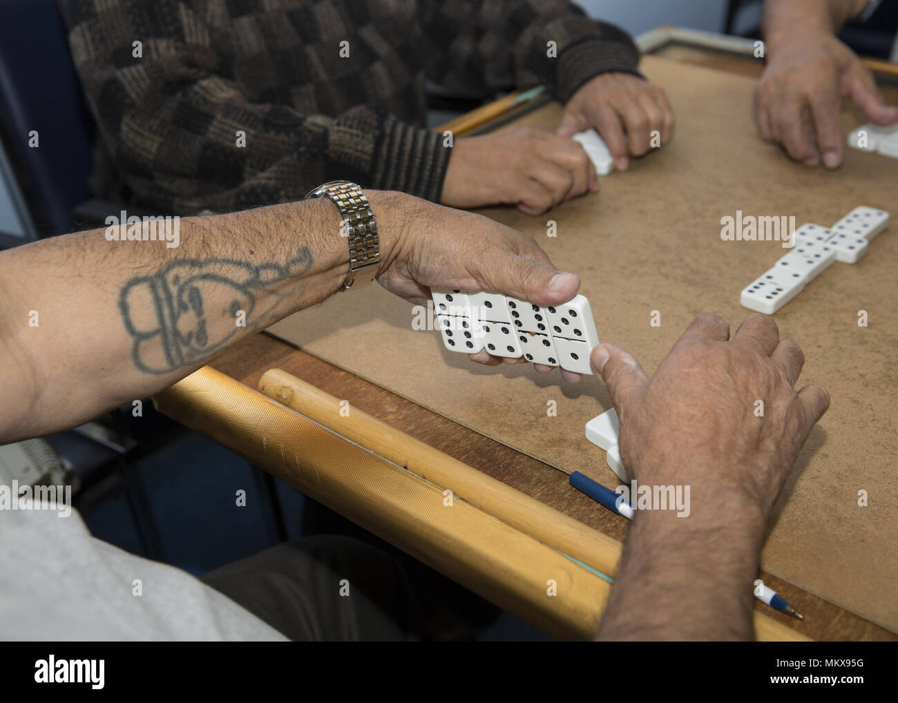 Men at a Lower East Side senior center play a serious game of Dominos, Manhattan, New York City. Stock Photo