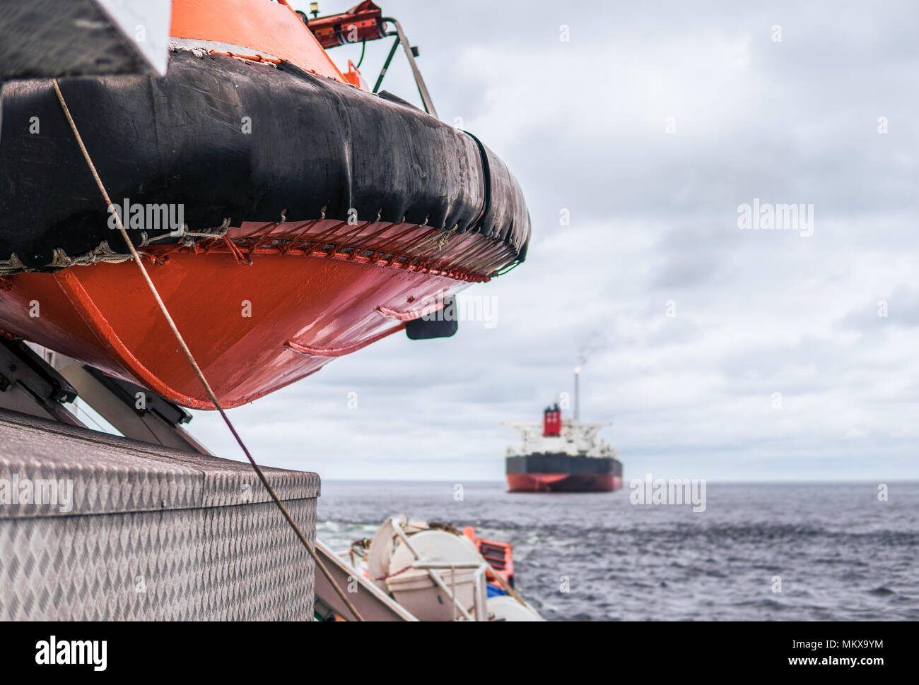 Lifeboat or FRC rescue boat in the vessel at sea. Tanker ship is on background Stock Photo
