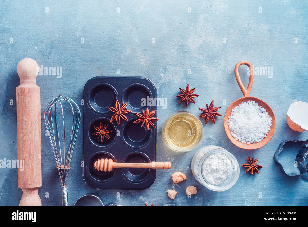 Making pastry concept with baking tools and ingredients on a modern concrete background with copy space. Wooden scoops, whisks, cookie cutters, muffin Stock Photo