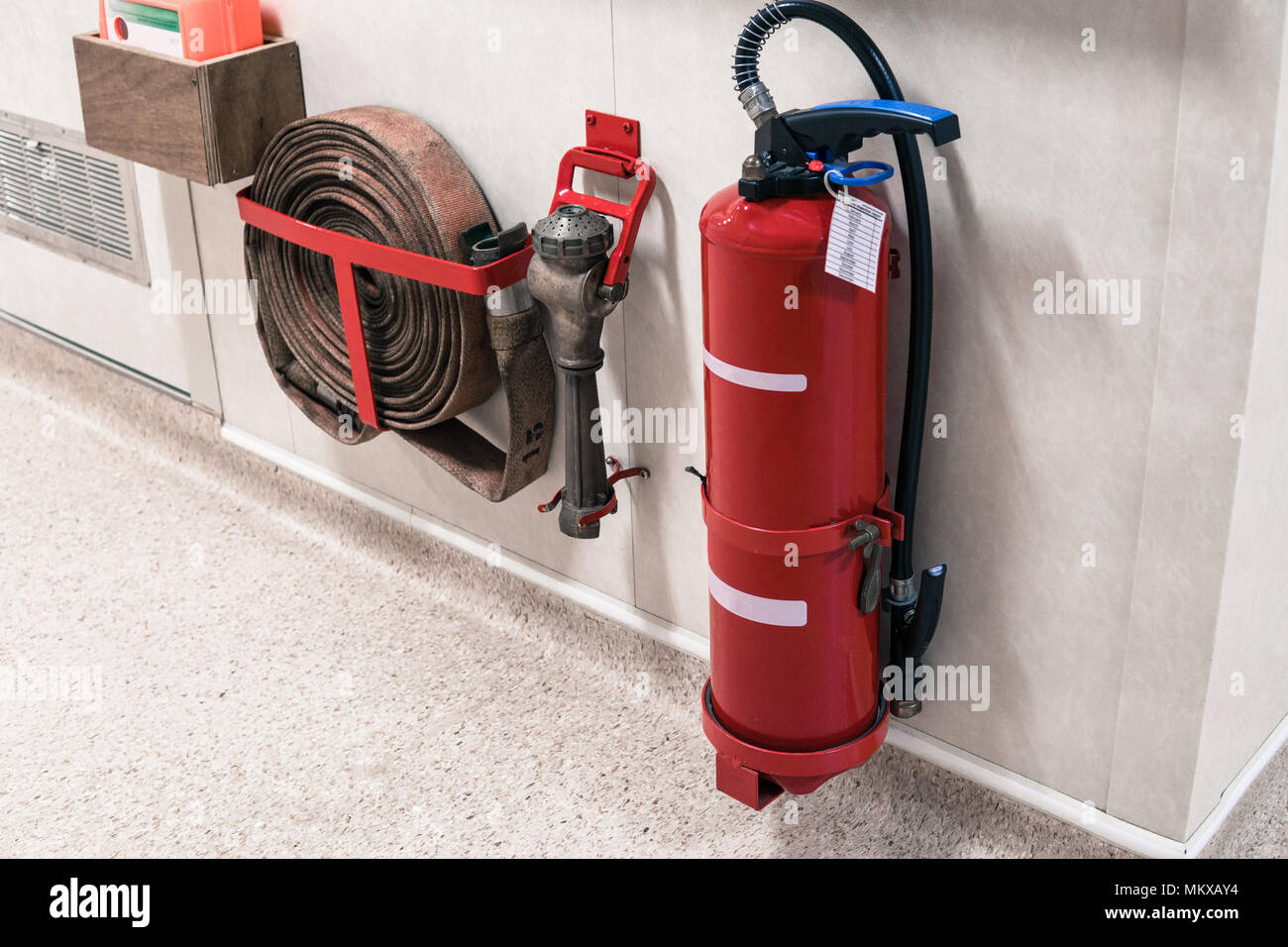 Fire extinguisher and fire hose reel in corridor Stock Photo