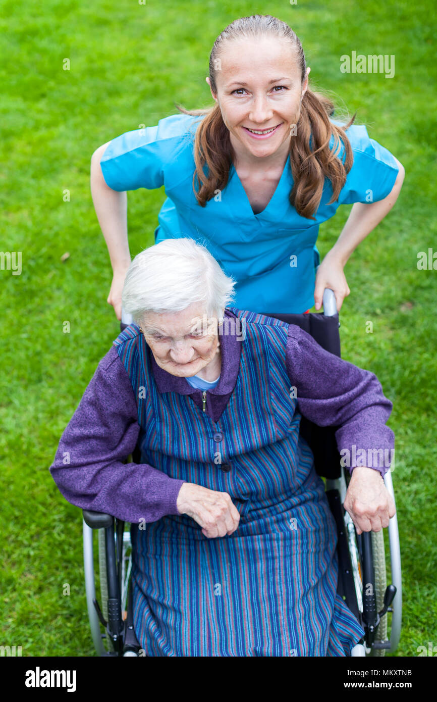 Portrait of elderly disabled woman sitting in a wheelchair spending