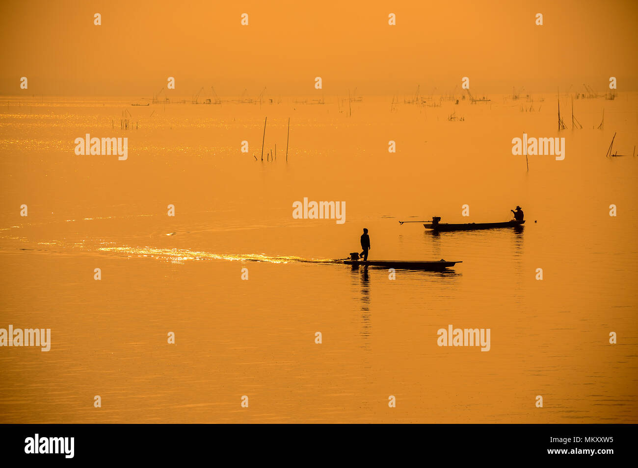 Silhouette fishermen on boat on river driving to fish Stock Photo - Alamy