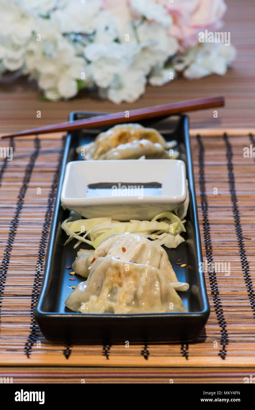 Plate of pork and vegetable Chinese potsticker dumplings with ginger