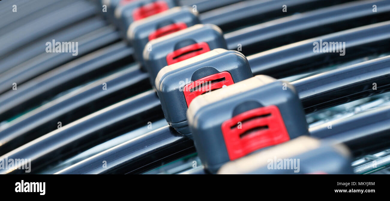 Close up of shopping carts with coin operated lock lined up in a row