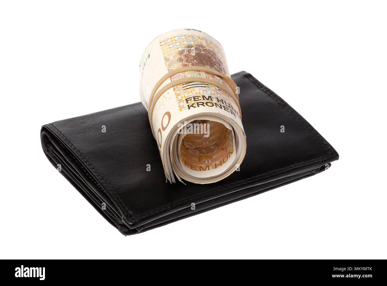 One roll Norwegian 500 Kroner banknotes on top a black wallet isolated onwhite background. Stock Photo