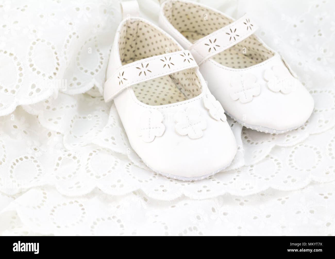 Baby white baptism or birthday dress and shoes close up with space for text Stock Photo