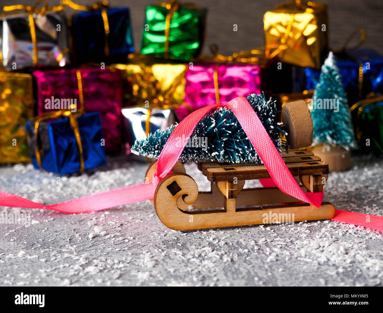 Christmas concept, toy santa sleigh, gift boxes on snow and blur bokeh ...