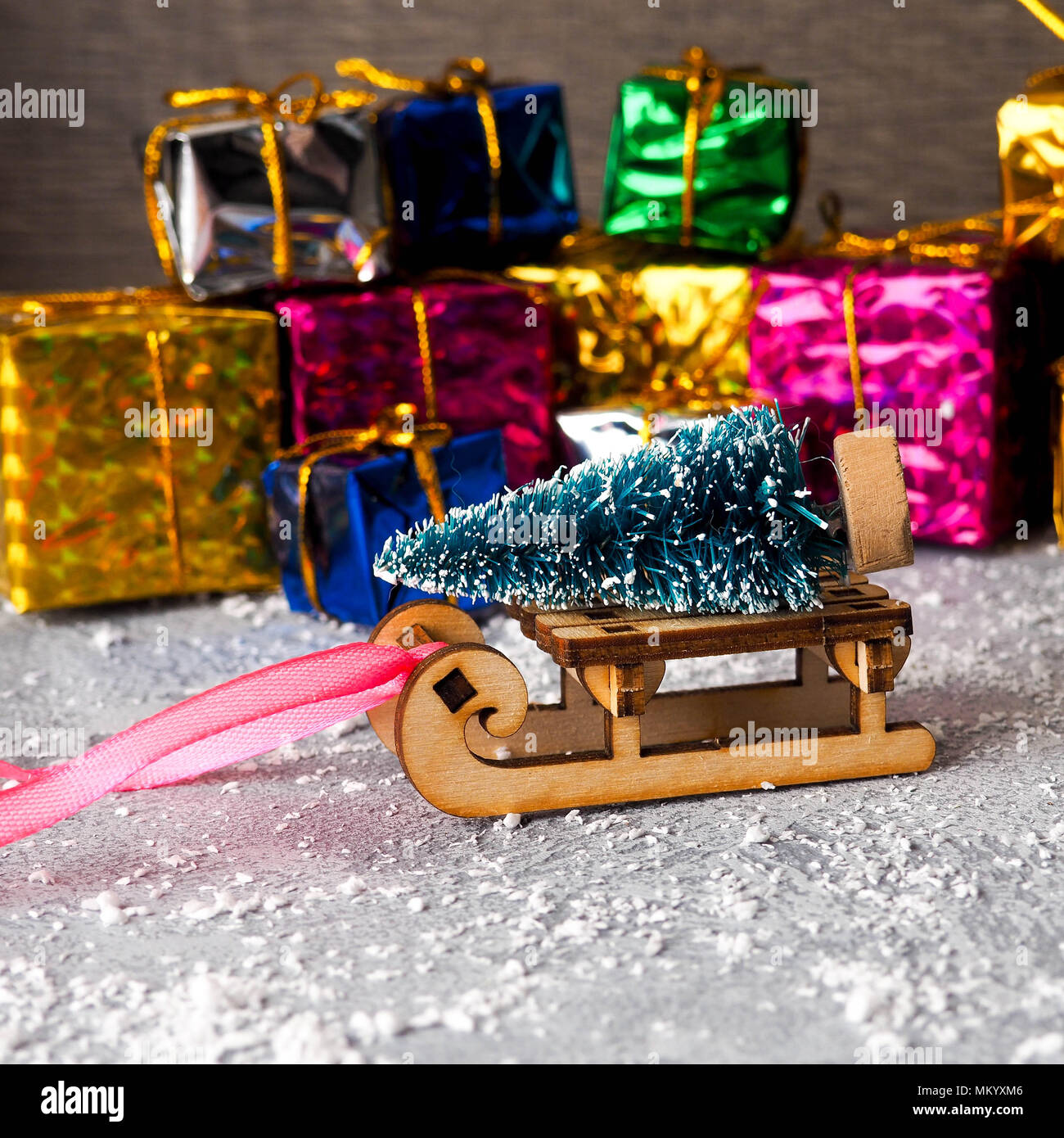 Christmas concept, toy santa sleigh, gift boxes on snow and blur bokeh ...