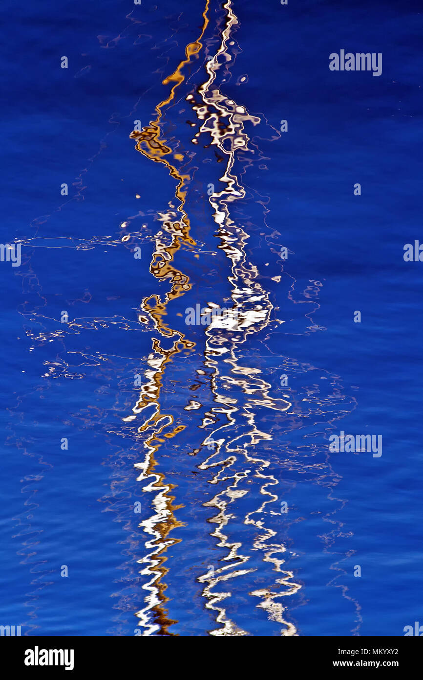 Ripples and reflections of yacht masts on sky-blue water in Scarborough ...