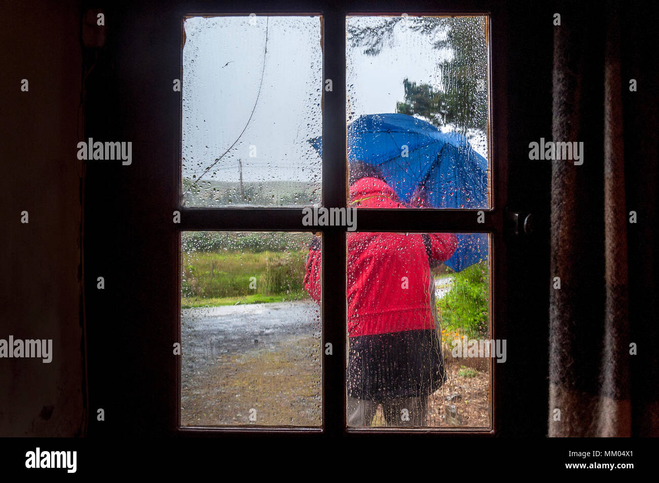 Ardara, County Donegal, Ireland  weather. 9th May 2016. A person struggles to work on a rainy, windy start to the day on Ireland's west coast. Seen through the window of a cottage. Credit: Richard Wayman/Alamy Live News Stock Photo