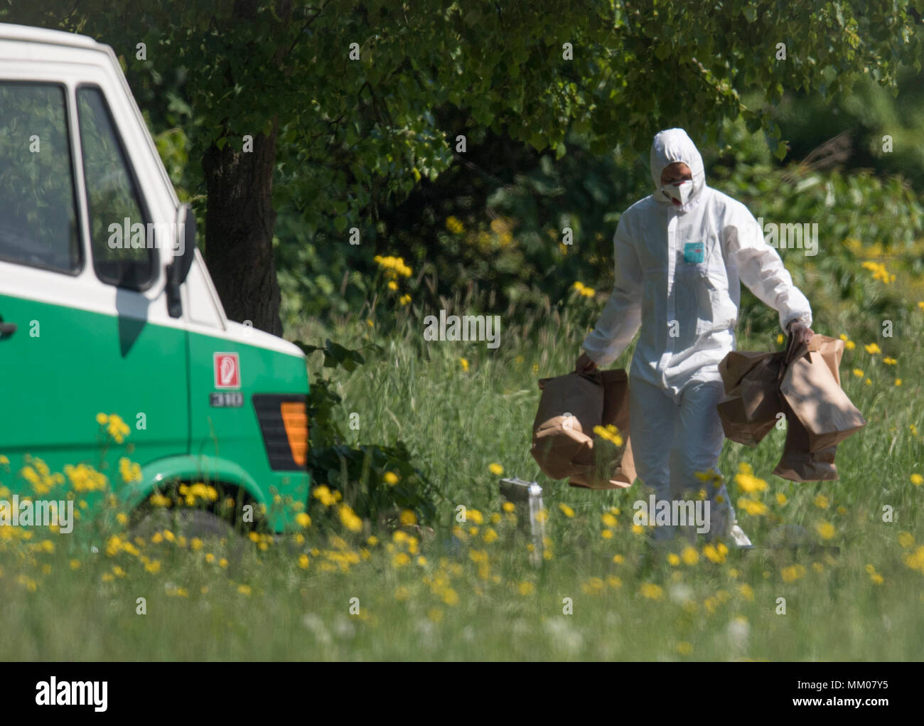 09 May 2018, Germany, Frankfurt/Main: Employees of the forensics department of the police secure evidence at the site where a female body was found. According to first police reports, the non-identified woman was the victim of a violent crime. Walkers found the life-less body in the morning at the edge of a park. Photo: Boris Roessler/dpa Stock Photo