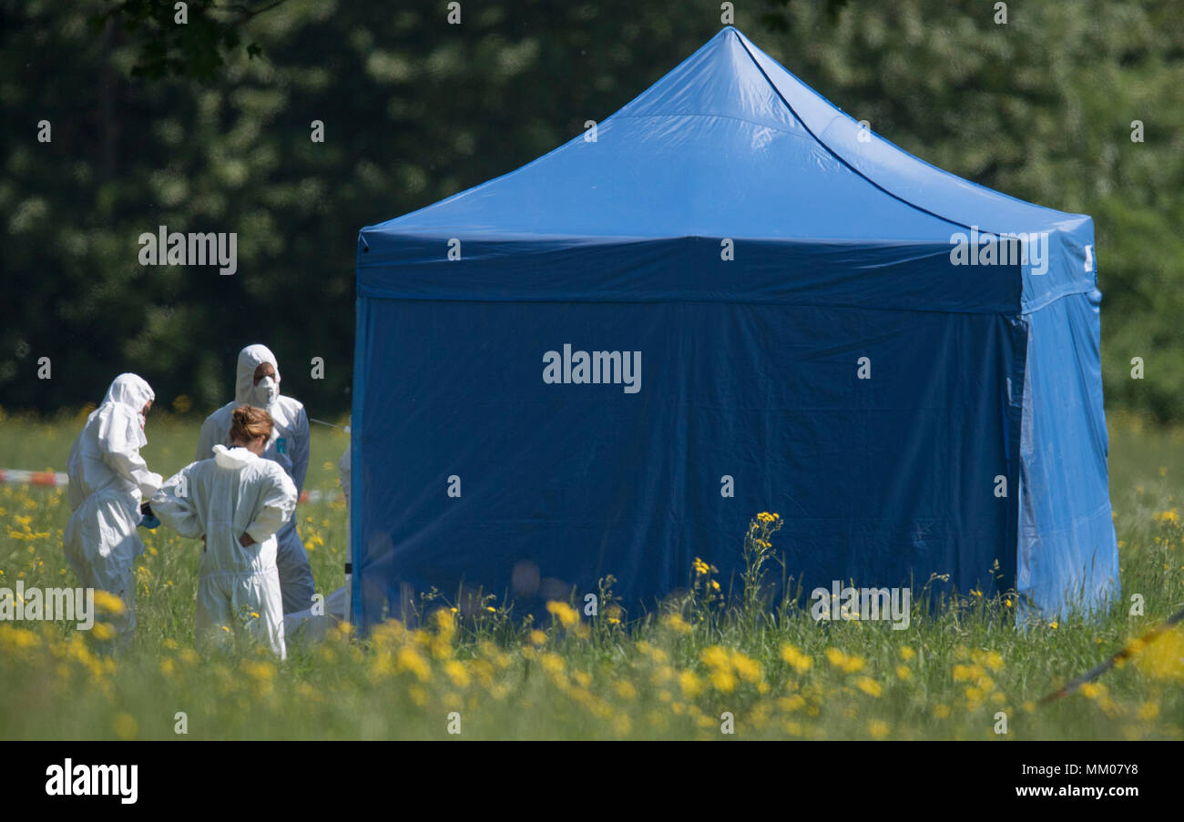 09 May 2018, Germany, Frankfurt/Main: Employees of the forensics department of the police secure evidence at the site where a female body was found. According to first police reports, the non-identified woman was the victim of a violent crime. Walkers found the life-less body in the morning at the edge of a park. Photo: Boris Roessler/dpa Stock Photo