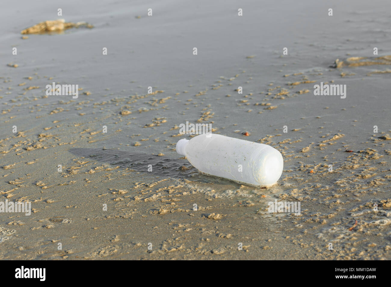 Discarded water bottle laying on a beach. Stock Photo