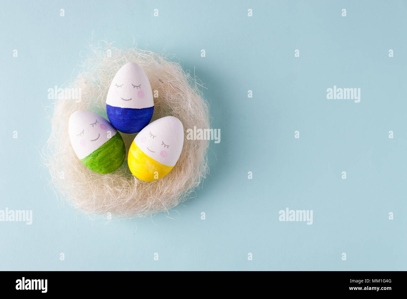 funny cute eggs in the nest jon blue pastel background, trendy unplug relaxation concept Stock Photo