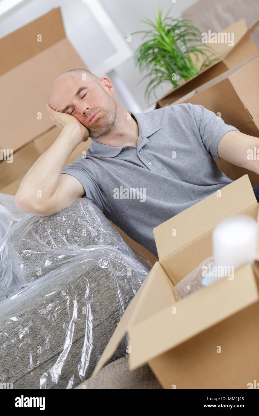 tired young man napping on couch in new house Stock Photo Alamy