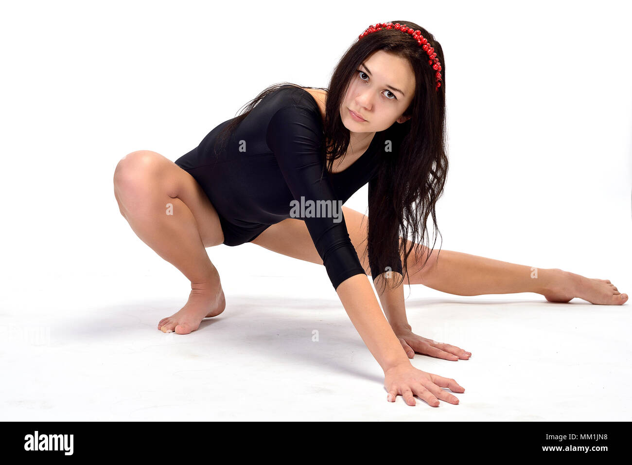 Girl, brunette, performs gymnastic exercises, athletic black body (isolated on white) Stock Photo