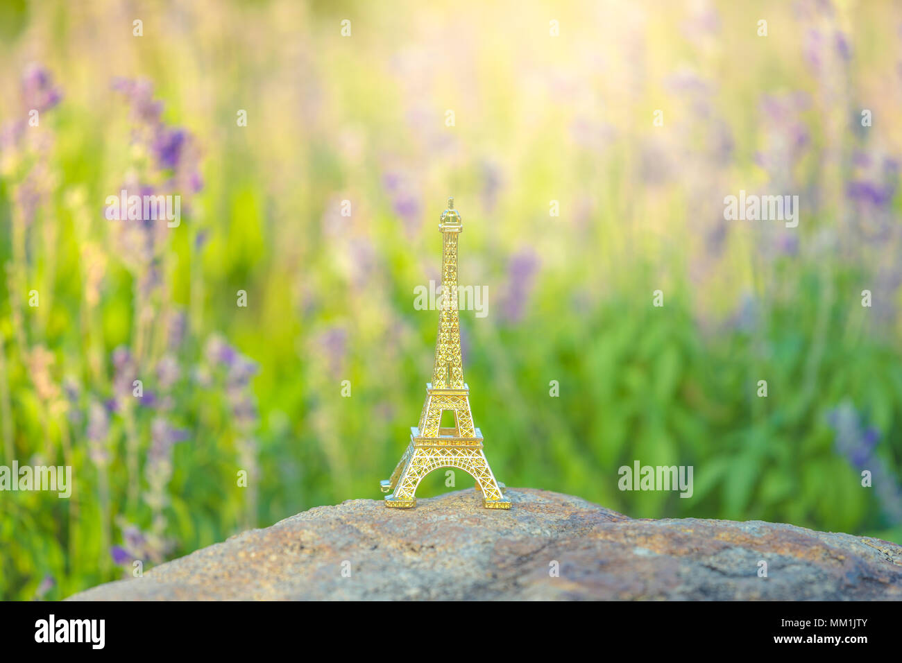 bright image of a miniaturized eiffel tower with lavander fields in background in day . french culture . Stock Photo