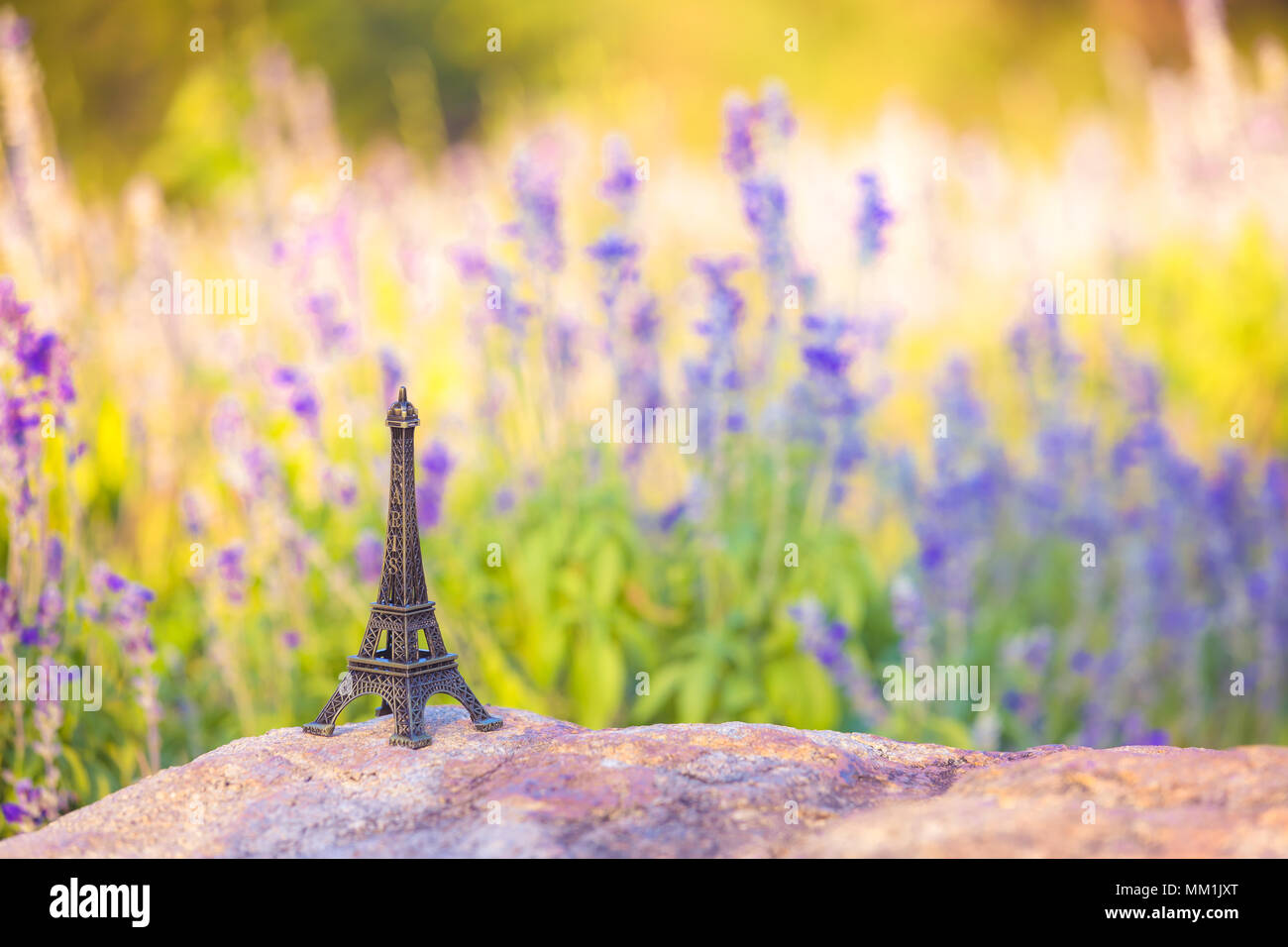 bright image of a miniaturized eiffel tower with lavander fields in background in day . french culture . Stock Photo