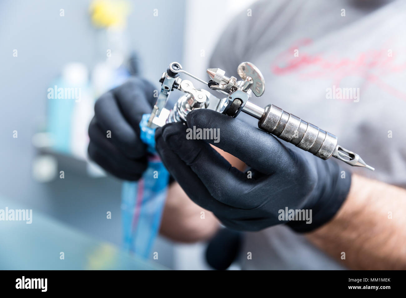 Closeup of the hands of a skilled tattoo artist wearing black gloves