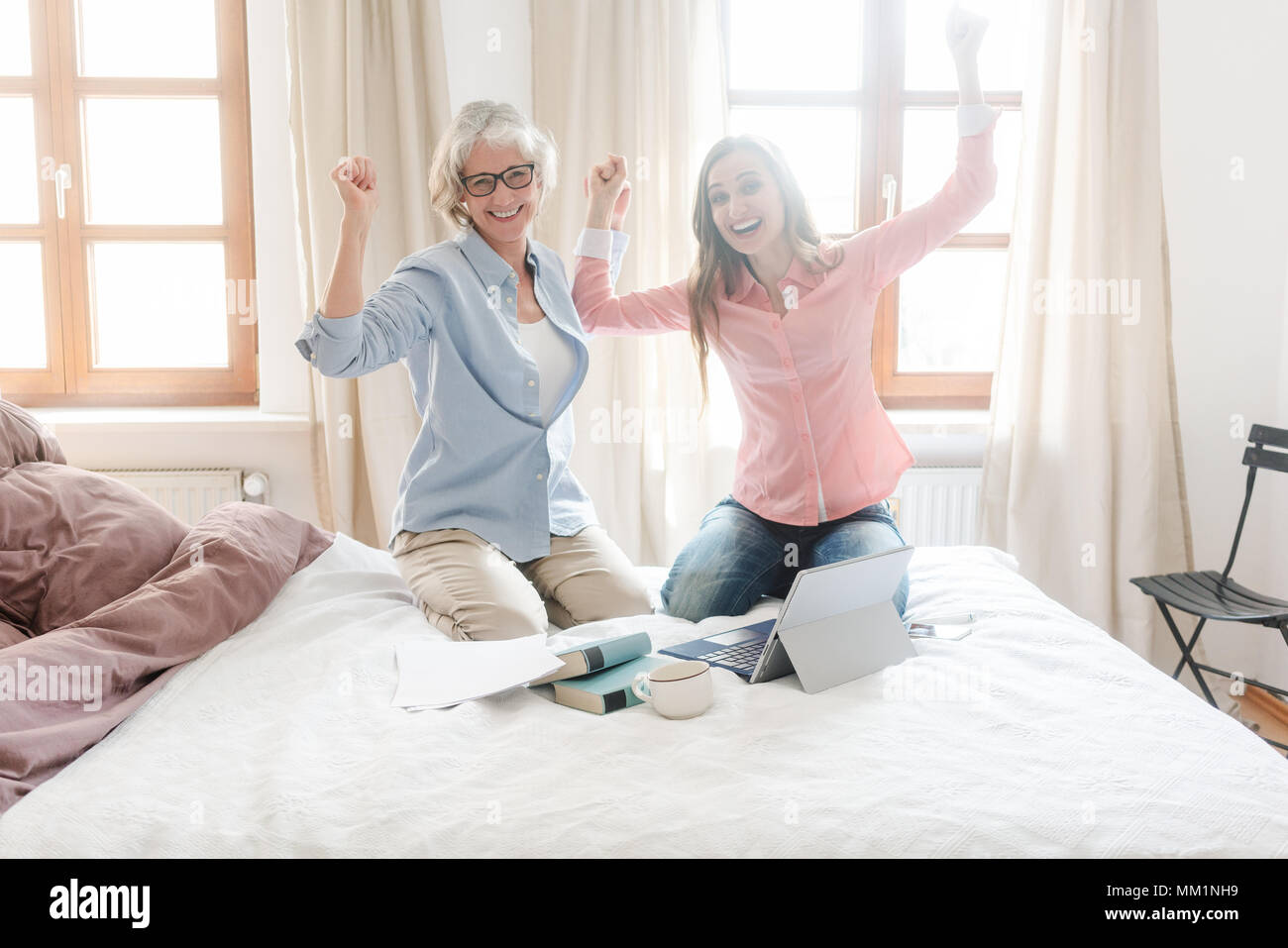 Mother and daughter working together giving high-five Stock Photo