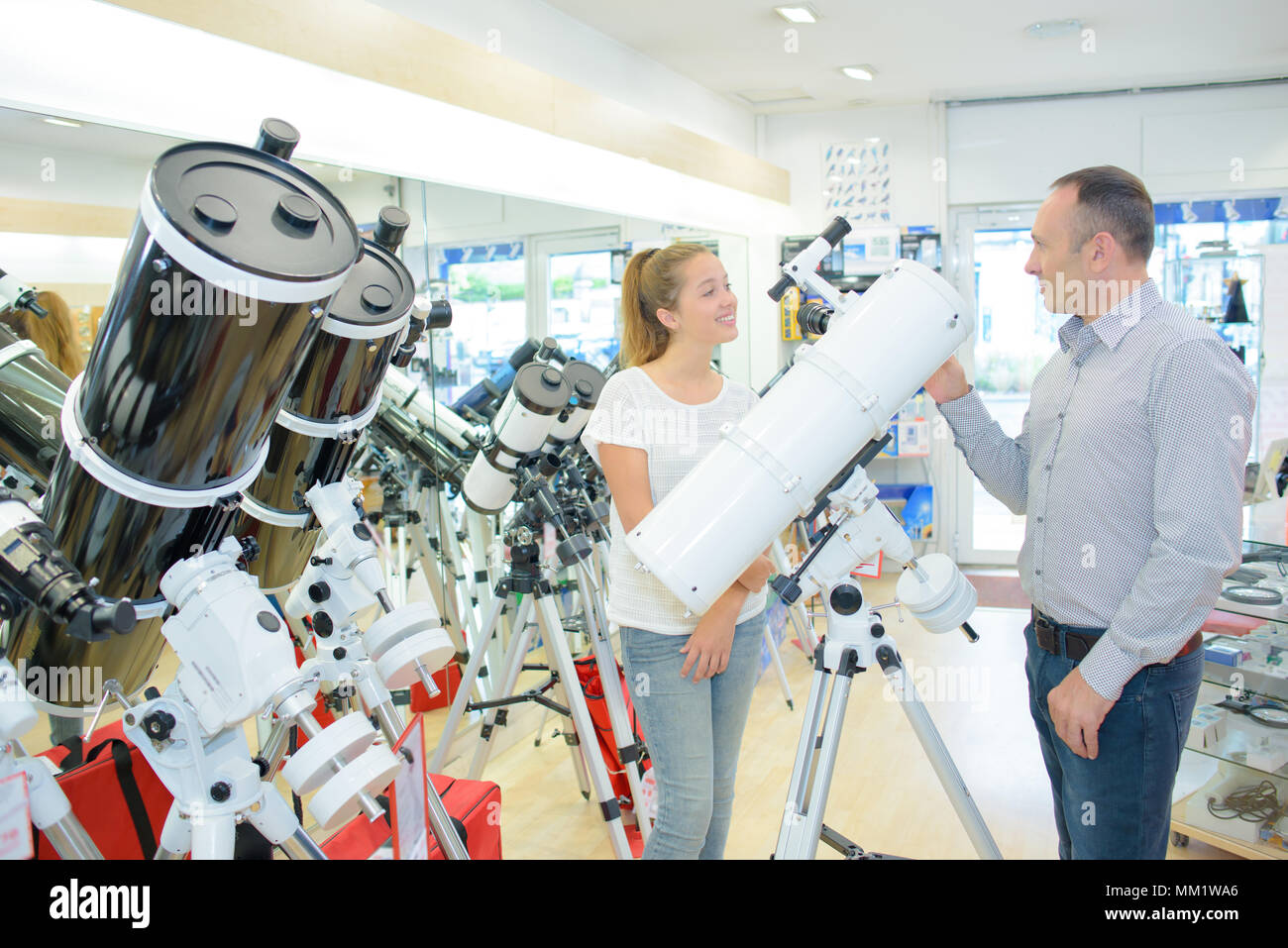 Two people in telescope store Stock Photo Alamy