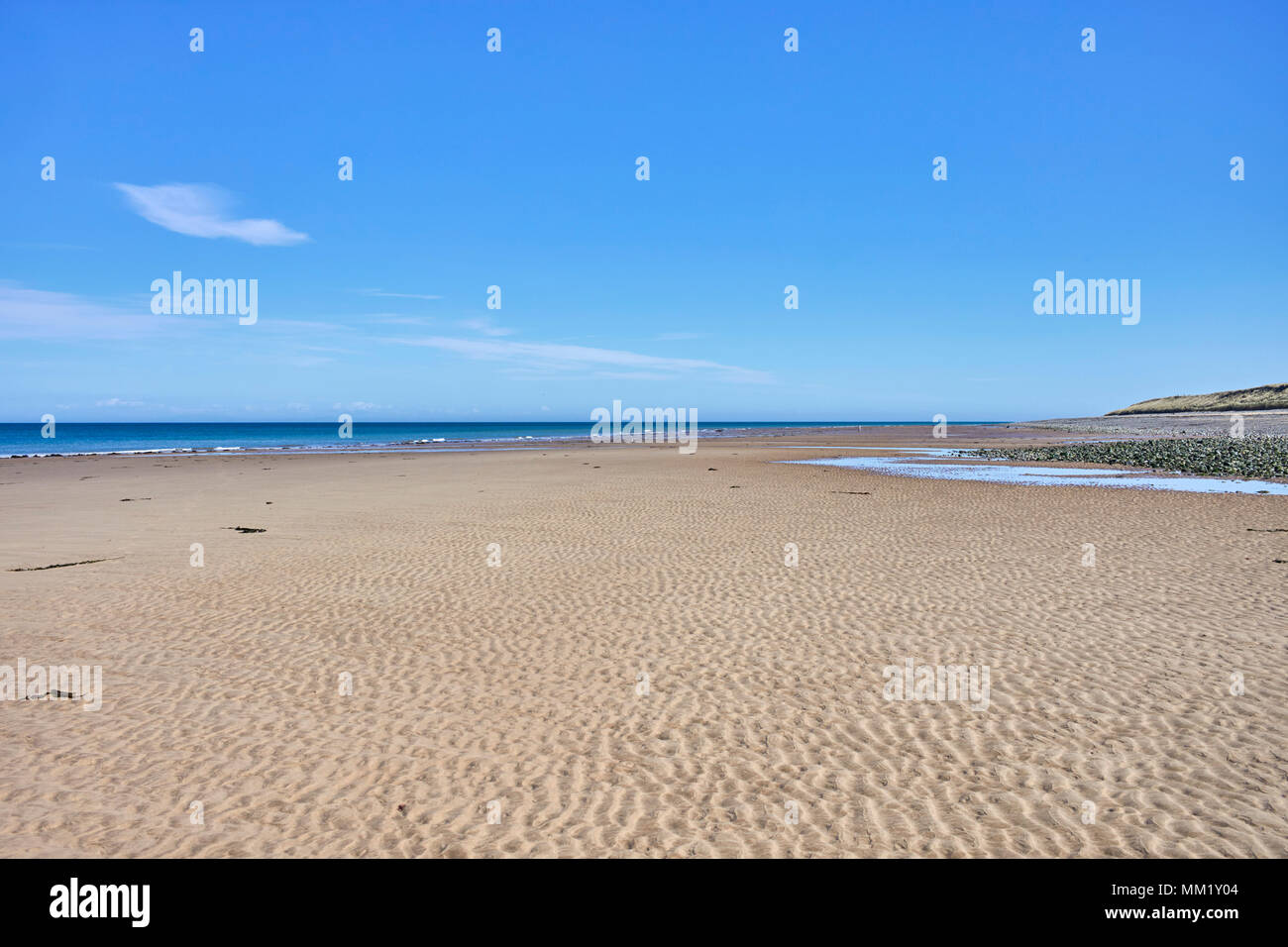 Blue sky and rippled sand on the very northern point of the Isle of Man near to Jurby church Stock Photo