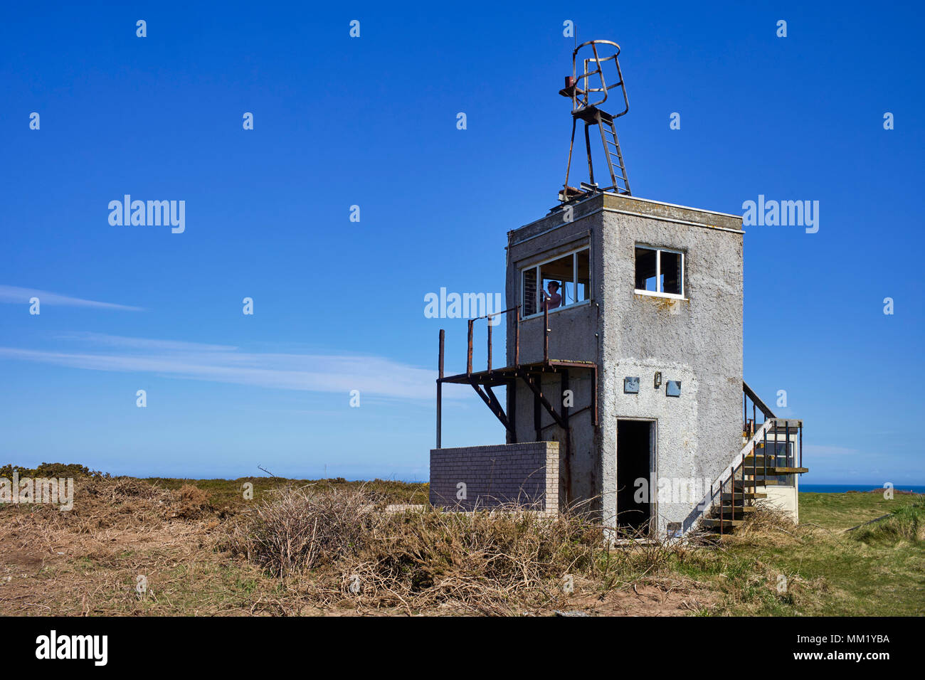 Woman takes a photo from the abandoned lookout tower at Blue Point, Jurby, Isle of Man Stock Photo