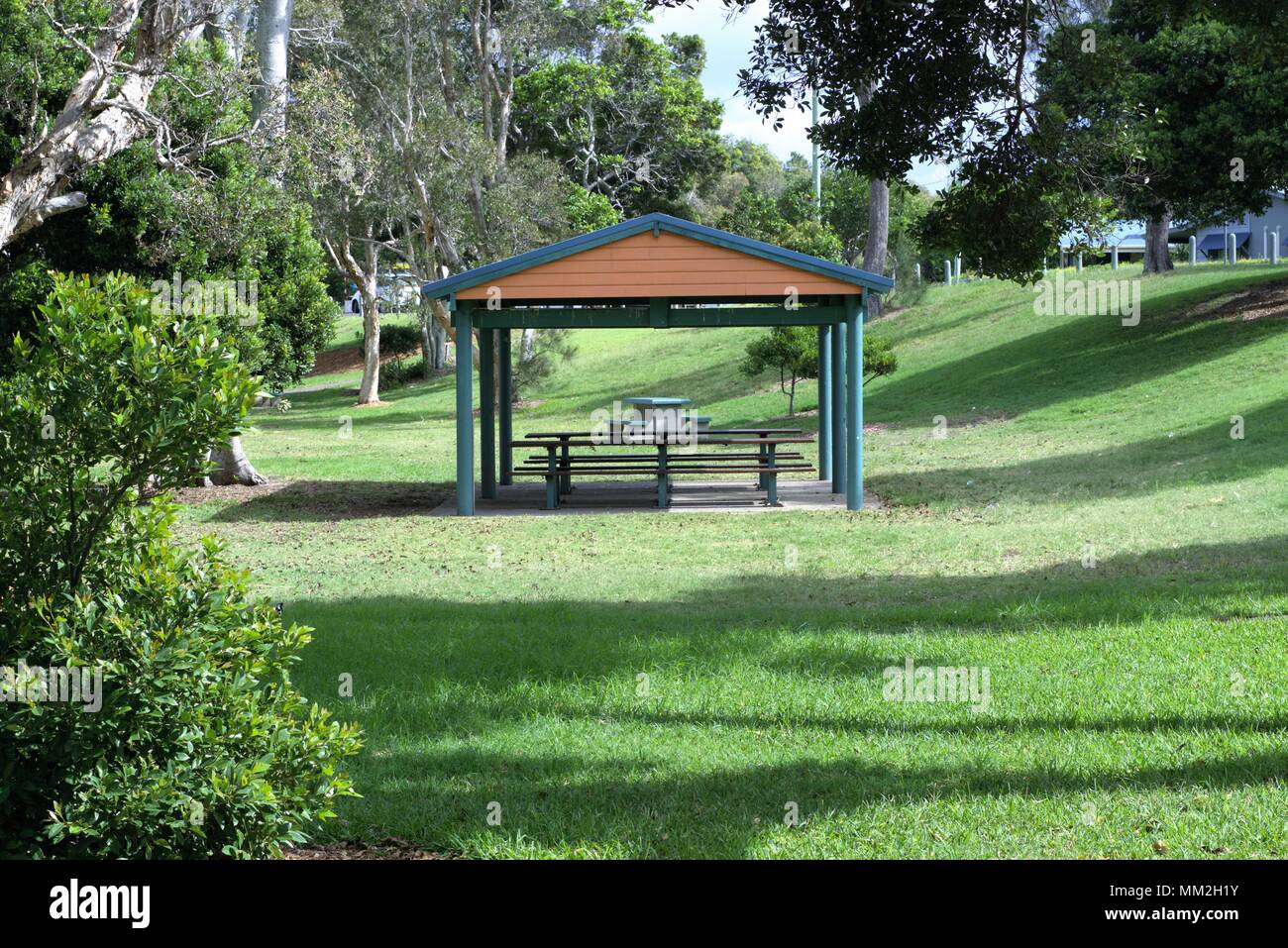 Garden shed with wooden table and bench seats in park. Gazebo in park in Australia Stock Photo