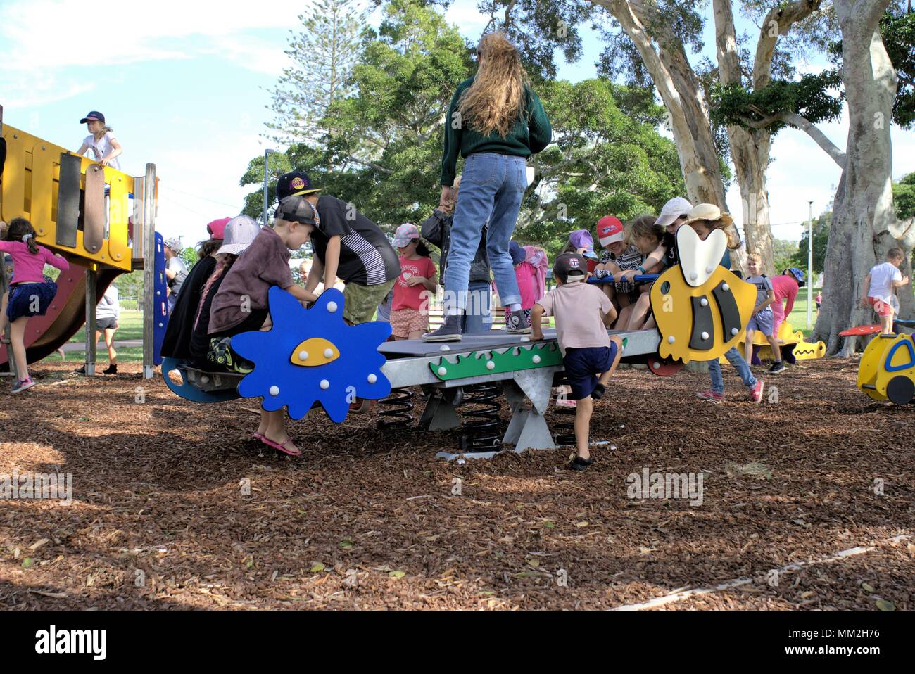 Lots of kids playing in park in Australia, Coffs Harbour. Many children climbed on to ride. Stock Photo